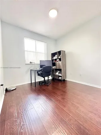 a view of a workspace with furniture and a window