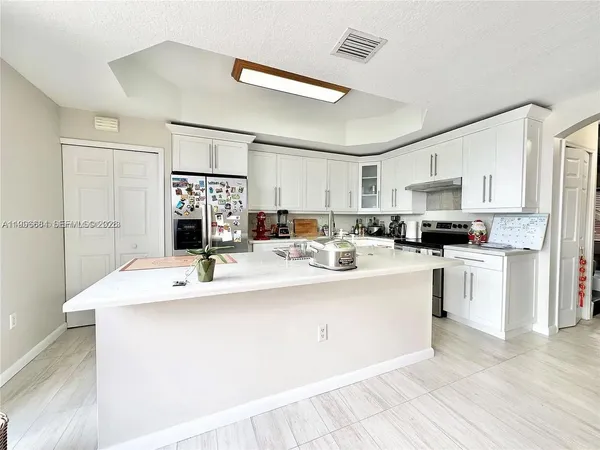 a kitchen with kitchen island a sink and white appliances