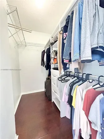 a view of walk in closet with clothes and shoes