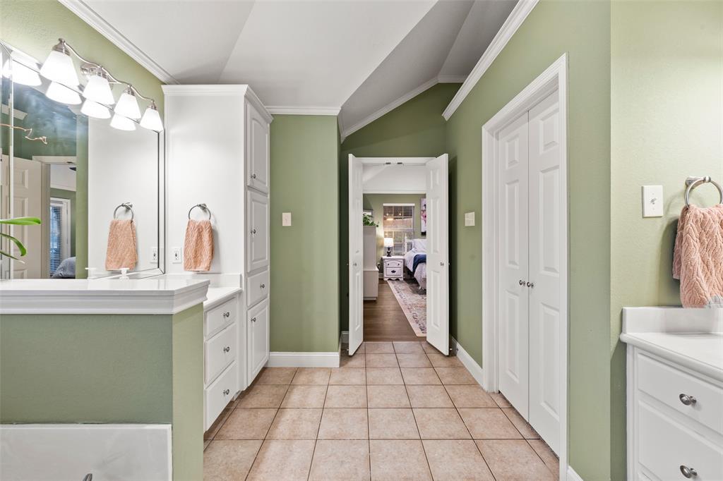 517 Chado Lane Robinson, TX 76706 - Photo 21 of 40 Primary Bathroom with ornamental molding, vanity, connected bathroom, lofted ceiling, and light tile patterned floors
