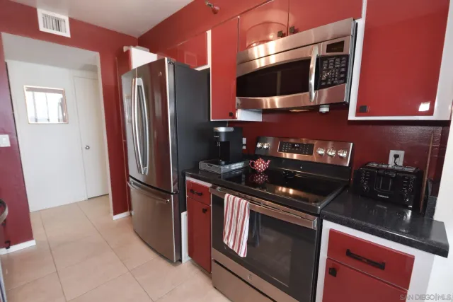 a kitchen with stainless steel appliances granite countertop a refrigerator and a stove top oven