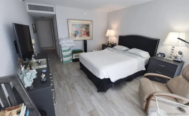 a bedroom with a bed lamps and dresser