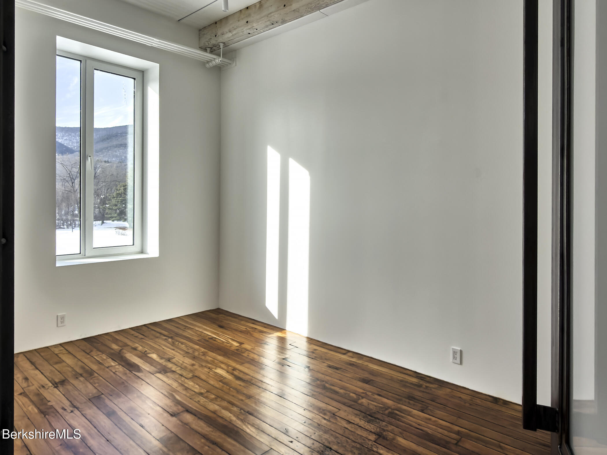 520 State Road, Unit 303 North Adams, MA 01247 - Photo 12 of 16 a view of empty room with wooden floor and fan