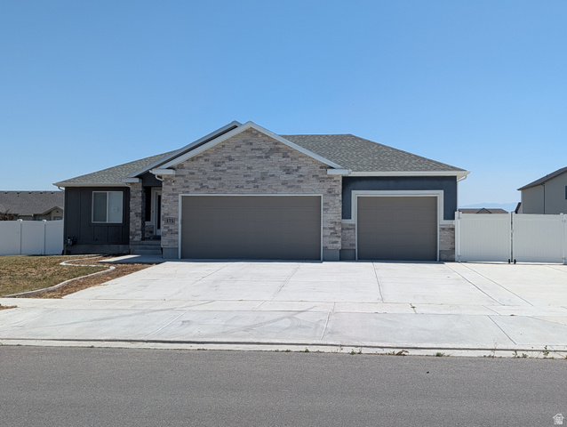 171 South Mustang Road East Grantsville, UT 84029 - Photo 33 of 41 Ranch-style residence featuring a stone and stucco exterior, a two-car garage, and an additional single-car garage