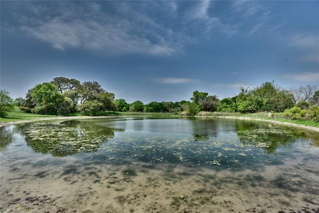 an aerial view of a residential houses with outdoor space and trees