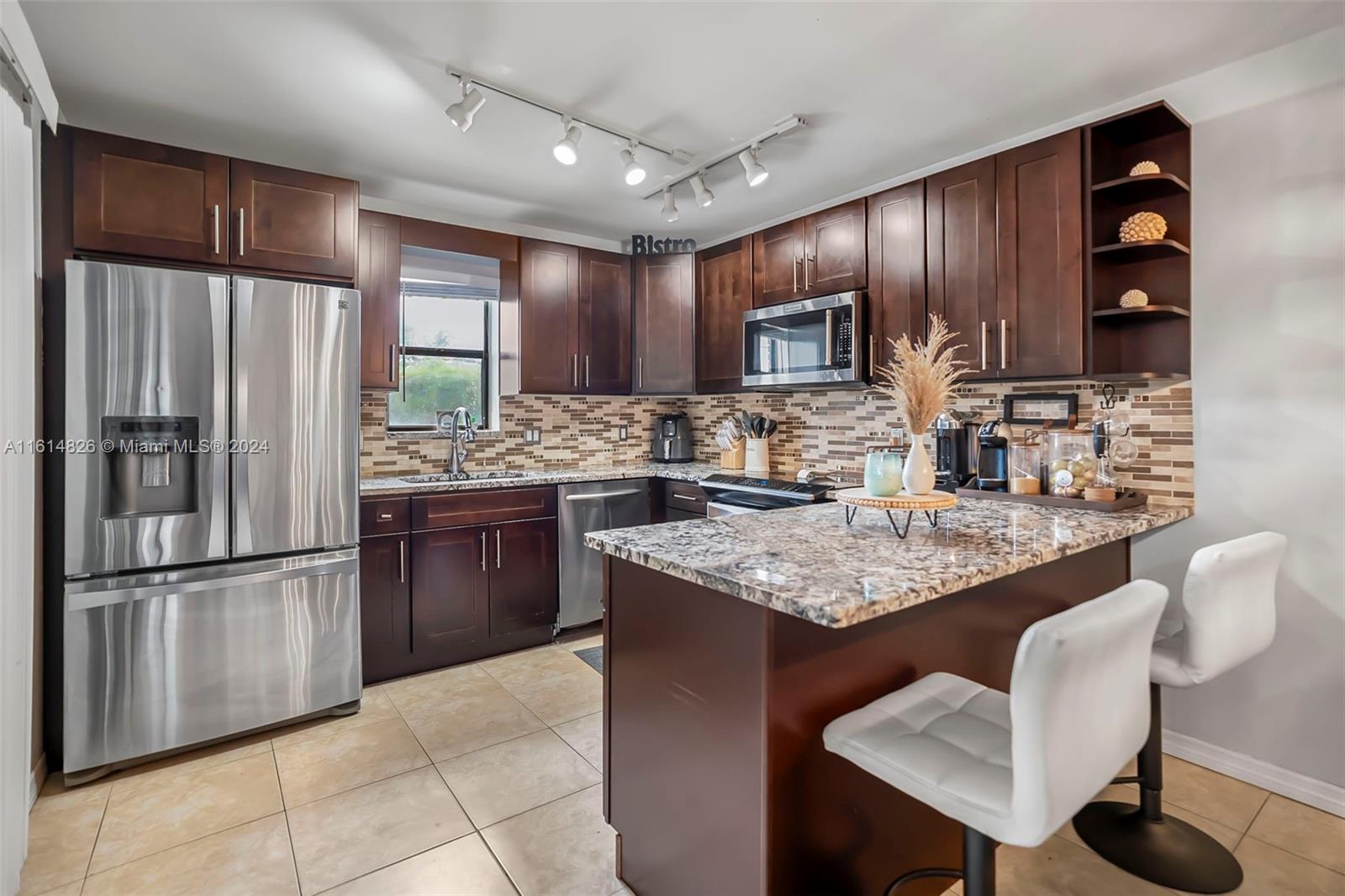 7643 Courtyard Run West Boca Raton, FL 33433 - Photo 11 of 35 a kitchen with stainless steel appliances granite countertop a stove refrigerator sink and cabinets