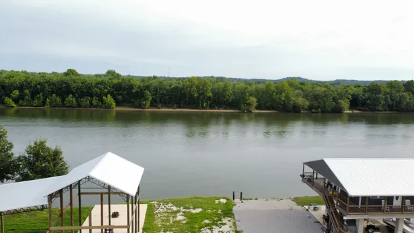 an aerial view of a house with garden space and lake view