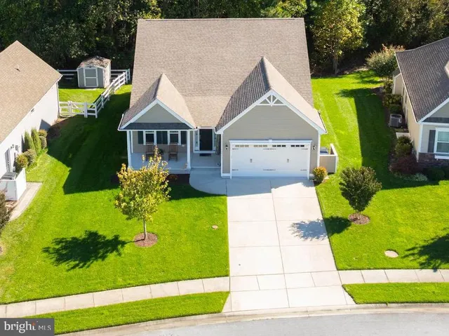 a view of a house with a big yard plants and large trees