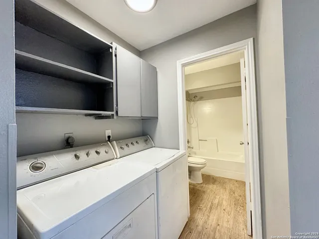 a room with a washing machine and a flat screen tv