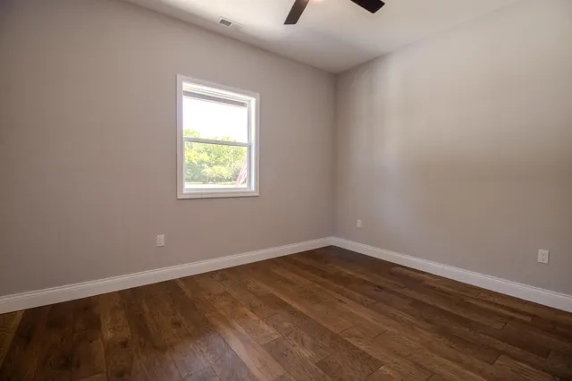 wooden floor in an empty room with a window