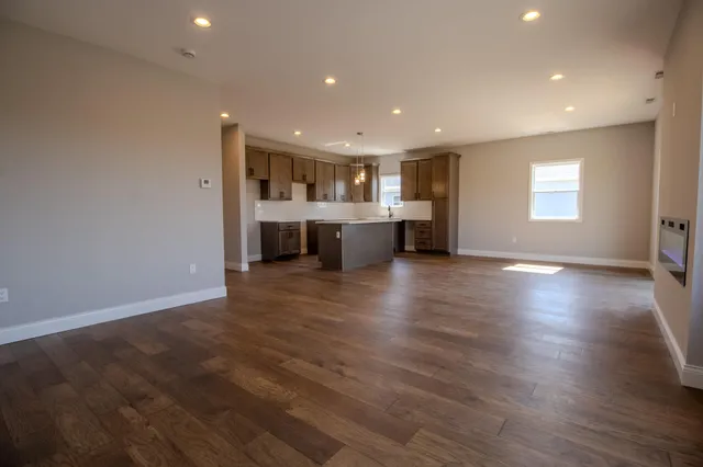 an empty room with wooden floor and window