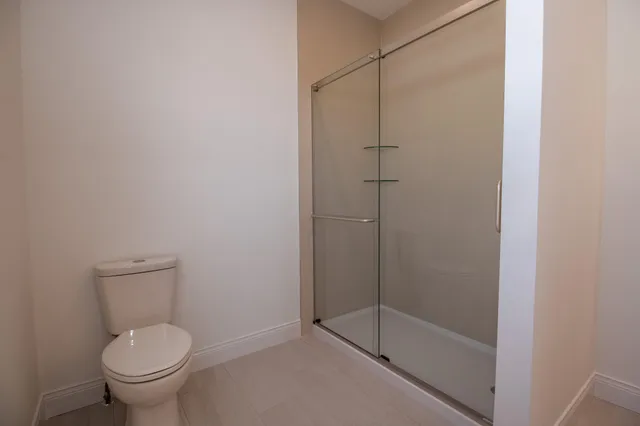 a bathroom with a granite countertop toilet and a shower