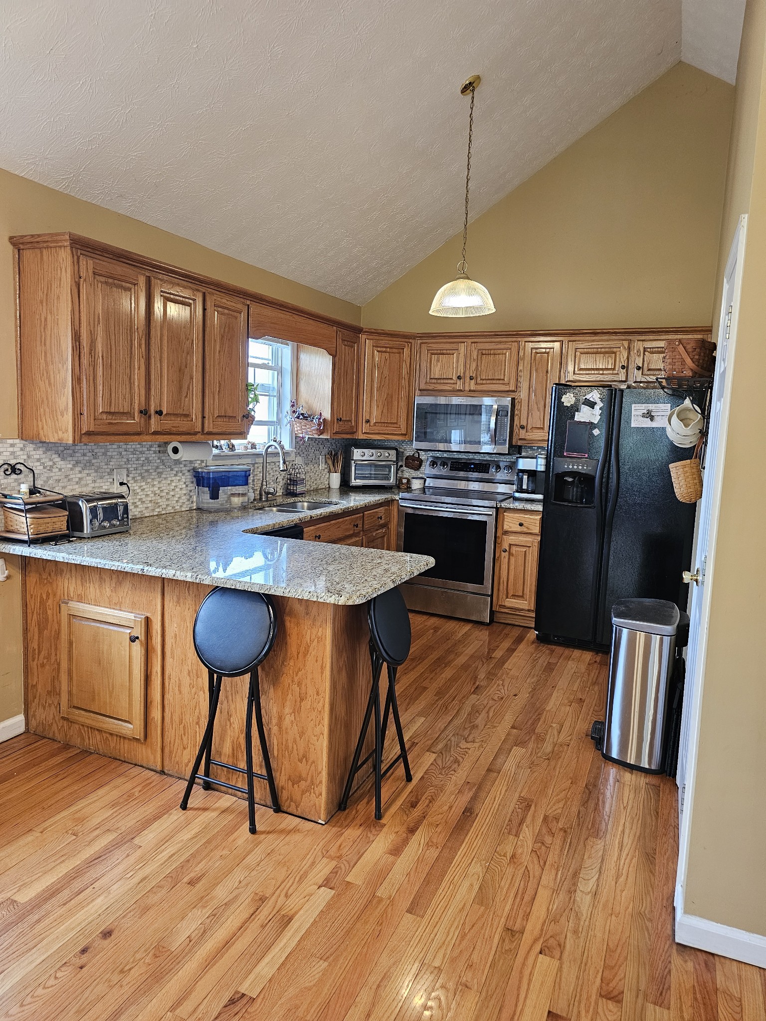 285 Browns Road Lafayette, TN 37083 - Photo 3 of 30 a kitchen with stainless steel appliances granite countertop a stove a refrigerator a sink dishwasher a dining table and chairs with wooden floor
