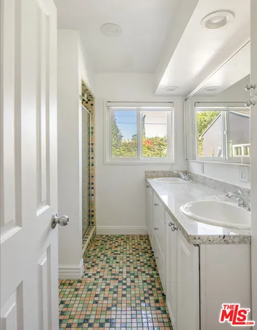 a bathroom with a granite countertop sink a toilet and a shower