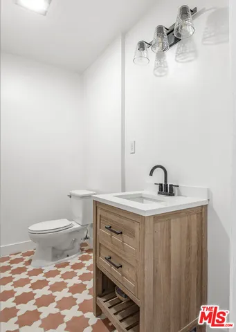 a bathroom with a granite countertop toilet and sink