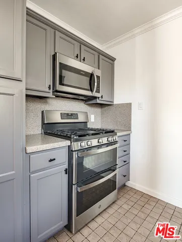 a kitchen with stainless steel appliances granite countertop a stove a microwave and a sink