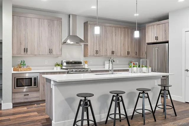 a kitchen with stainless steel appliances granite countertop a sink stove and refrigerator