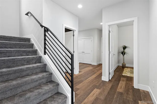 a view of a hallway with wooden floor and staircase