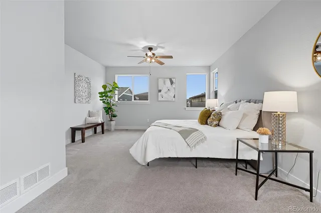 a bedroom with a bed a chandelier and a window