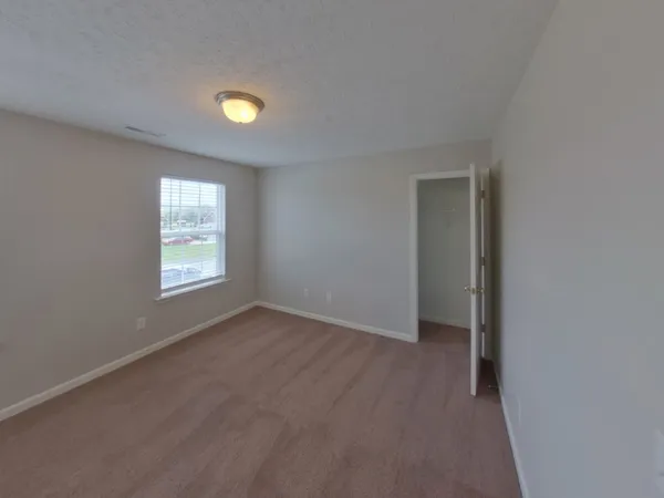 an empty room with windows and closet