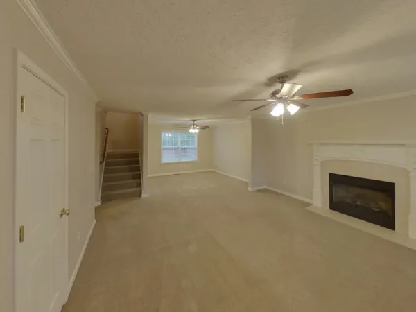 a view of an empty room with chandelier and fireplace