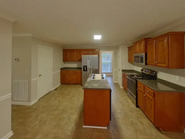a kitchen with stainless steel appliances granite countertop a stove refrigerator sink and microwave