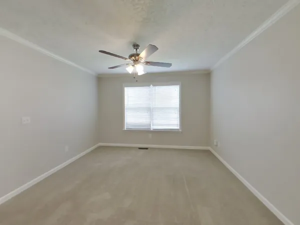 an empty room with a window and a fan