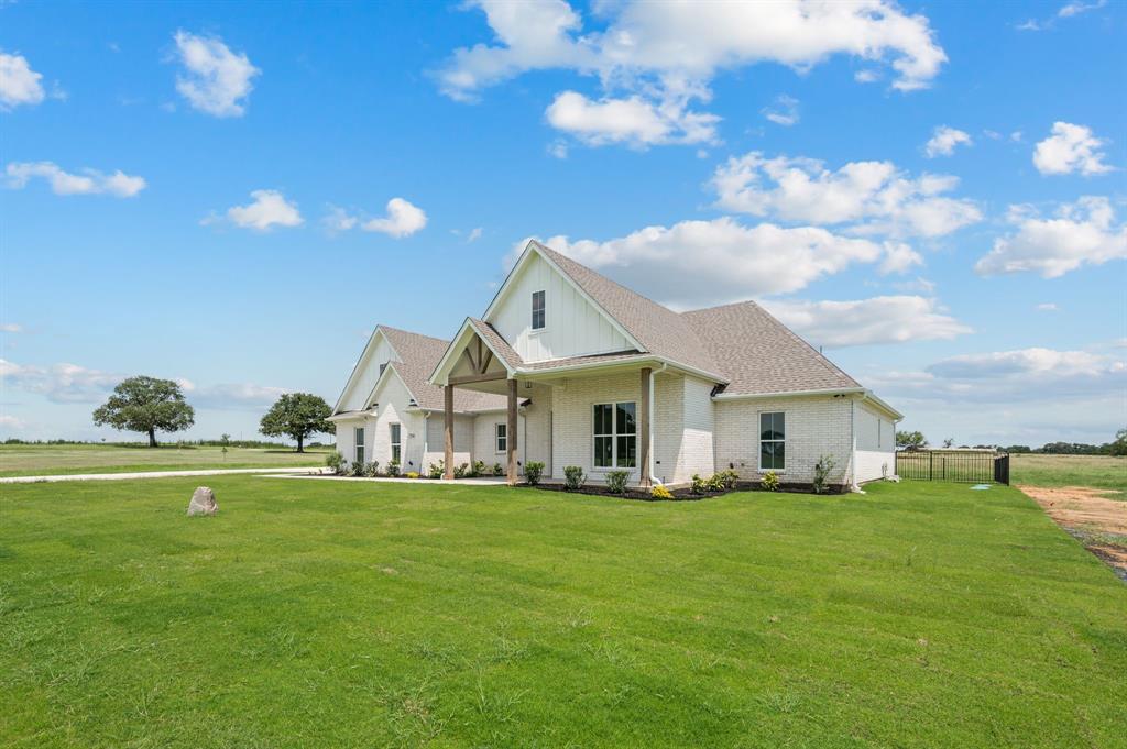 2705 Gospel Road Tolar, TX 76476 - Photo 5 of 36 Contemporary farmhouse exterior featuring white brick and board and batten siding