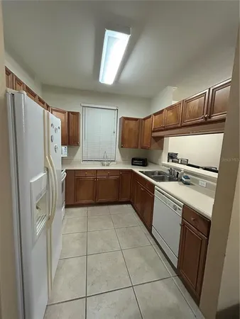 a kitchen with a refrigerator sink and cabinets