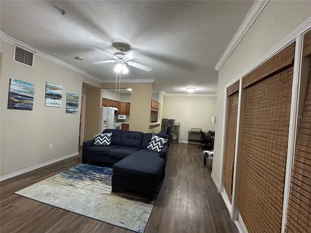 a living room with furniture and a wooden floor