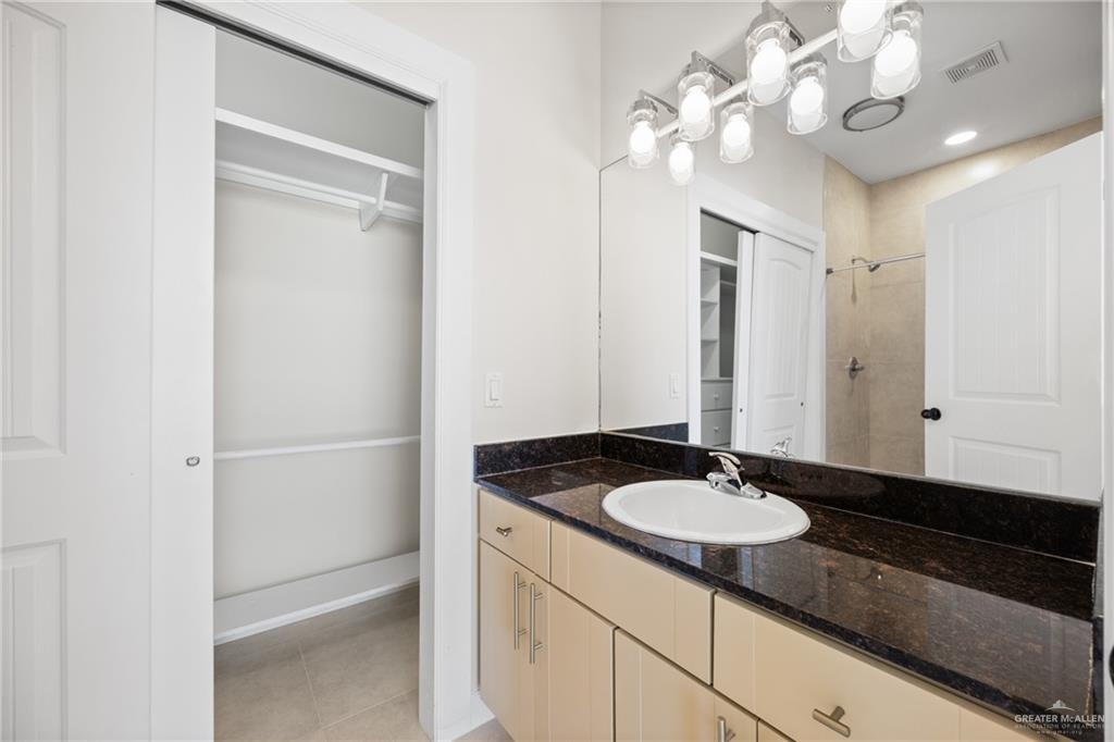 813 Travis Street, Unit 408 Mission, TX 78572 - Photo 12 of 25 a bathroom with a sink a light fixture and a mirror
