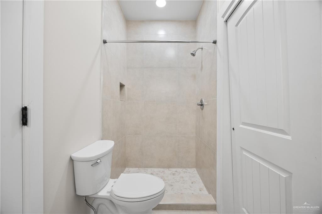 813 Travis Street, Unit 408 Mission, TX 78572 - Photo 13 of 25 a white toilet sitting next to a bathroom sink