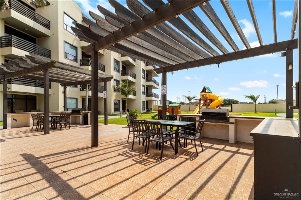 813 Travis Street, Unit 408 Mission, TX 78572 - Photo 19 of 25 a view of a patio with dining table and chairs with wooden floor