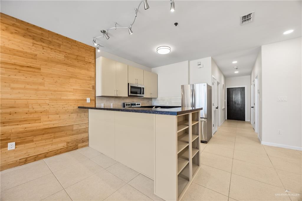 813 Travis Street, Unit 408 Mission, TX 78572 - Photo 6 of 25 a kitchen with stainless steel appliances a refrigerator sink and cabinets