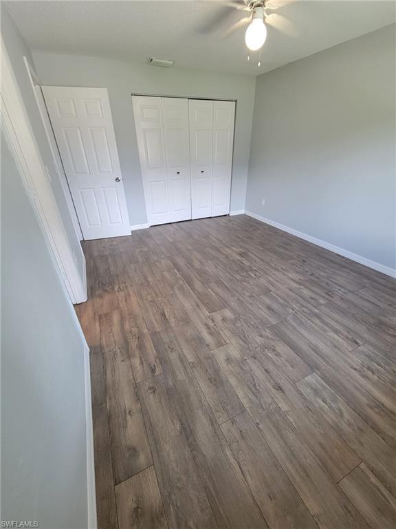 18613 Sebring Road Fort Myers, FL 33967 - Photo 6 of 12 an empty room with wooden floor and fan