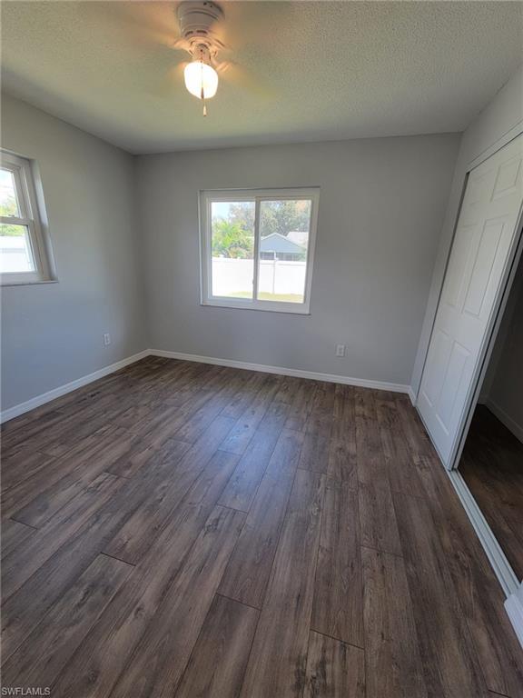 18613 Sebring Road Fort Myers, FL 33967 - Photo 7 of 12 an empty room with wooden floor and windows