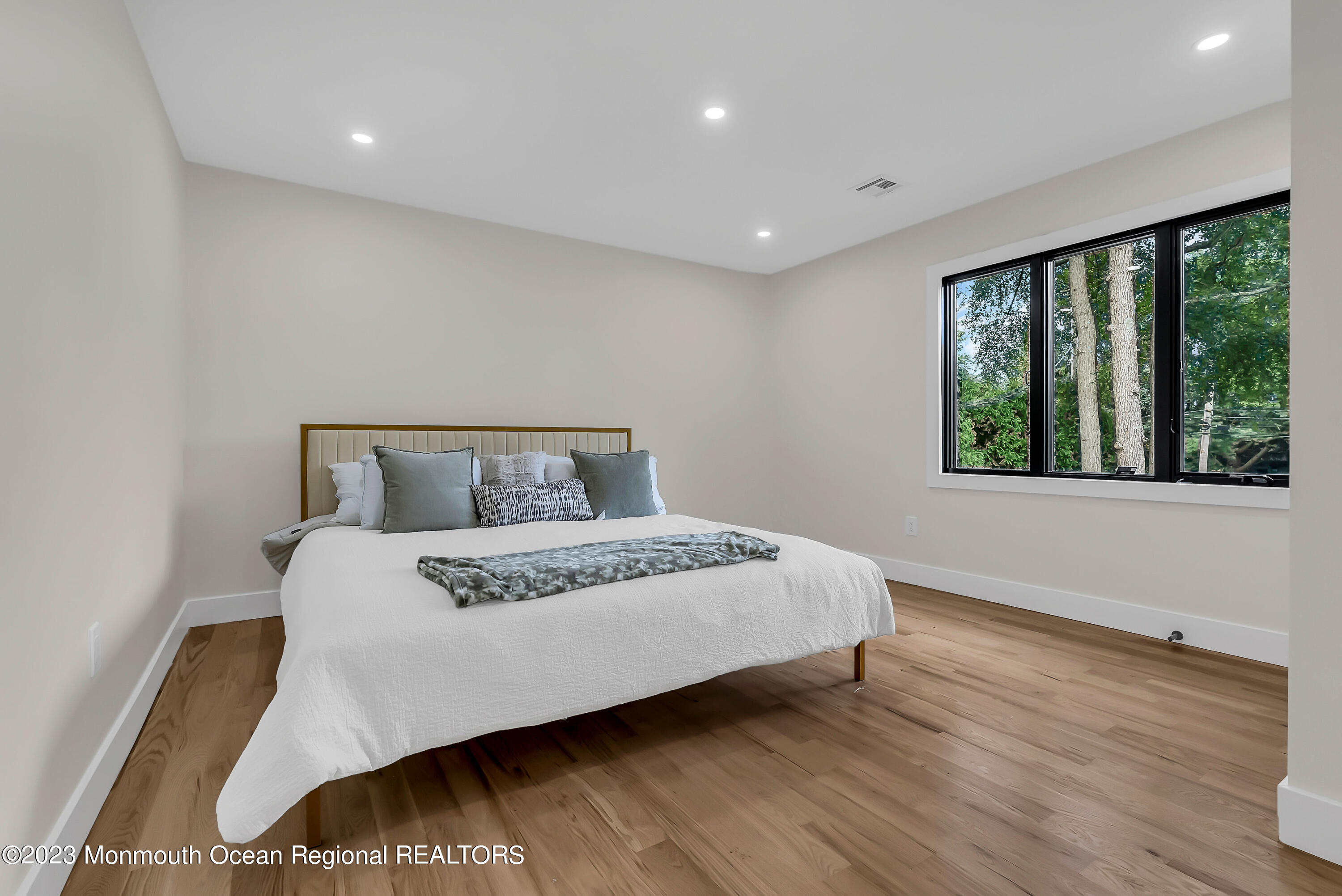 265 Whalepond Road Oakhurst, NJ 07755 - Photo 14 of 34 a bedroom with a large bed and wooden floor