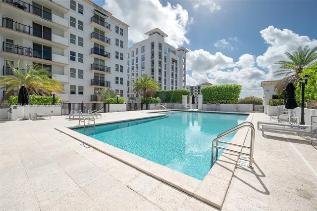 a view of a swimming pool with a bench in front of building