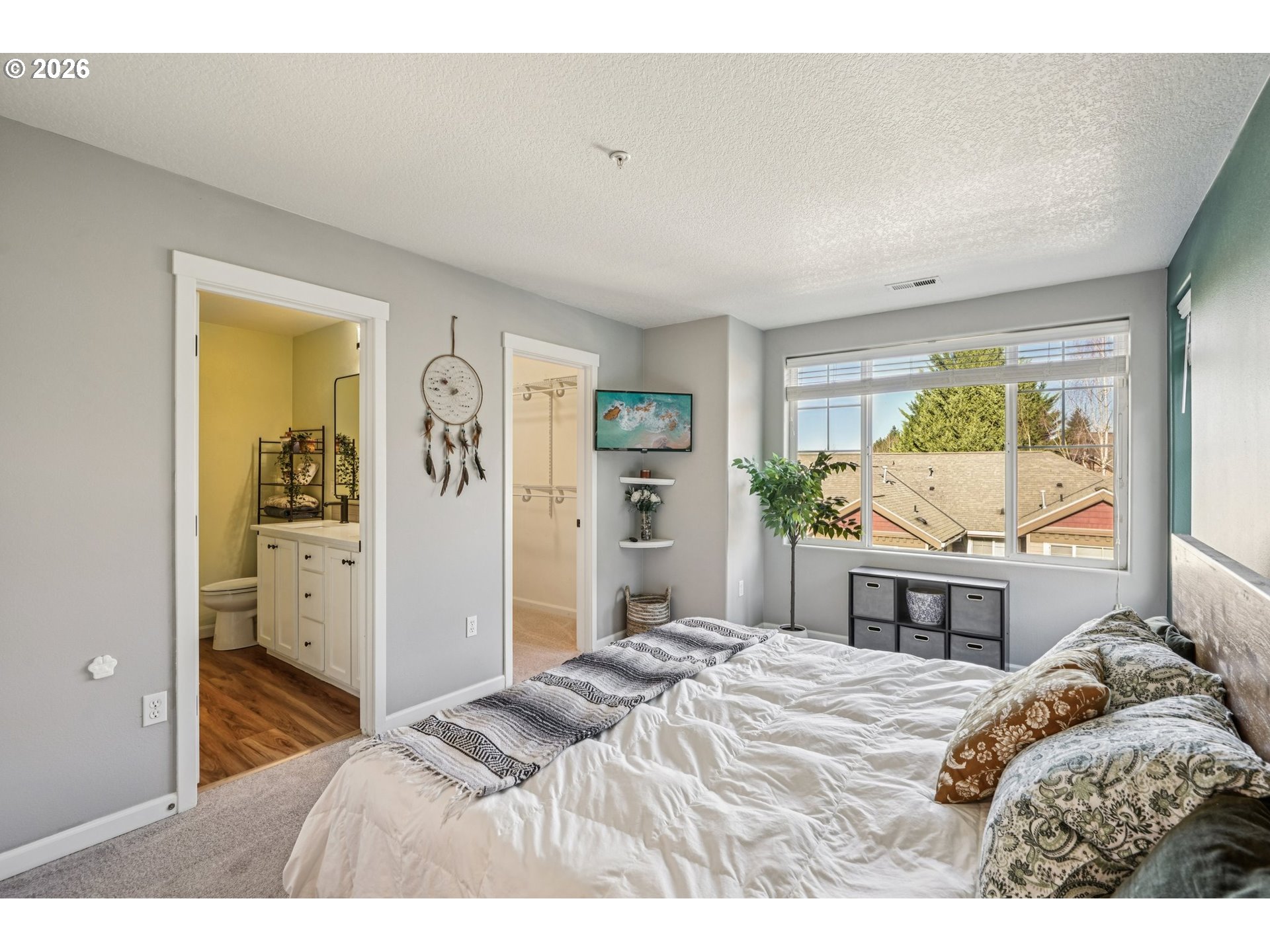 10739 Southwest Canterbury Lane, Unit 101 Portland, OR 97224 - Photo 13 of 27 a bedroom with a bed and dresser with mirror