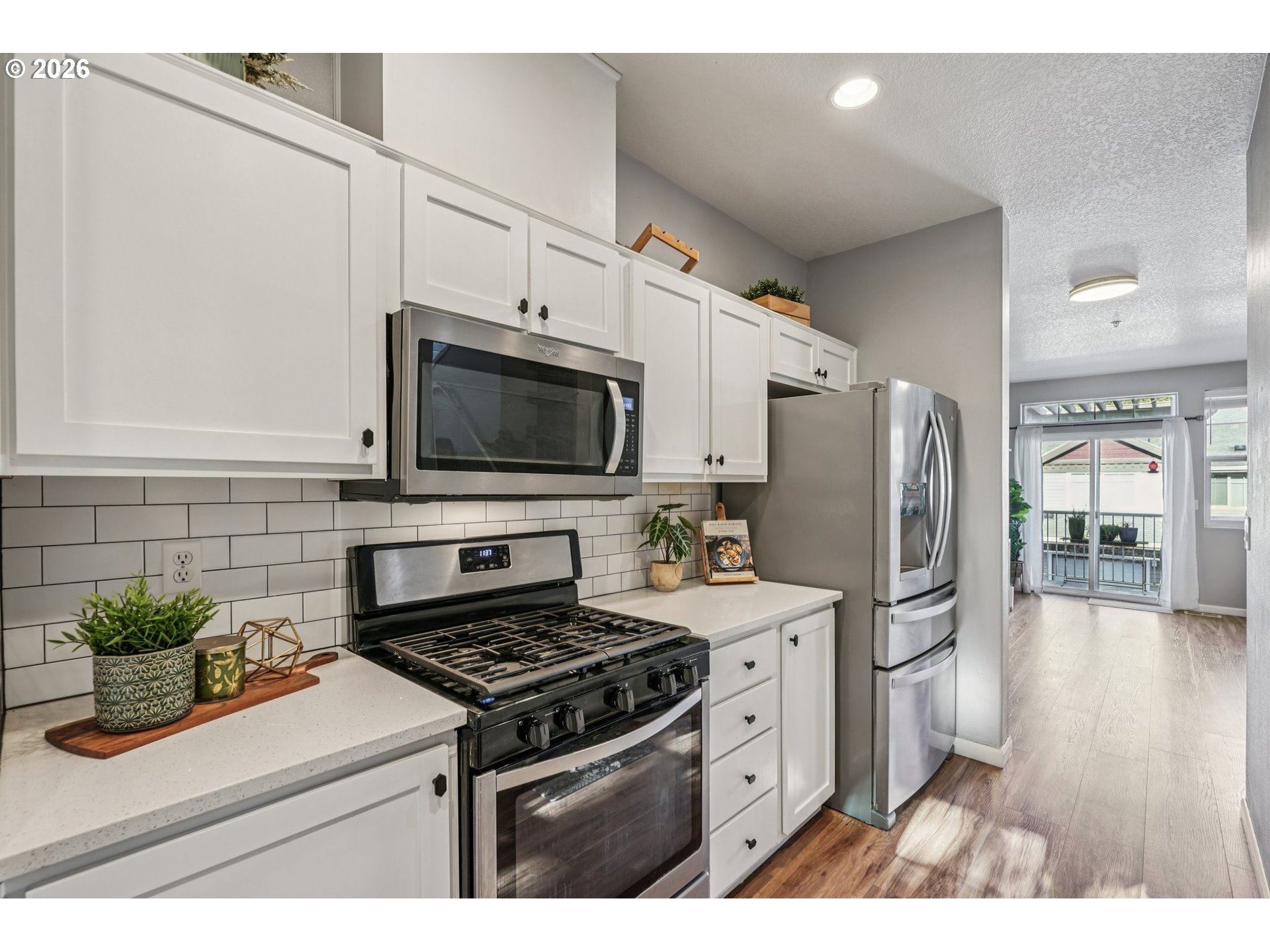 10739 Southwest Canterbury Lane, Unit 101 Portland, OR 97224 - Photo 9 of 27 a kitchen with stainless steel appliances kitchen island granite countertop a refrigerator stove and sink