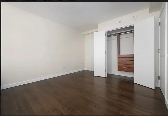 an empty room with wooden floor and closet