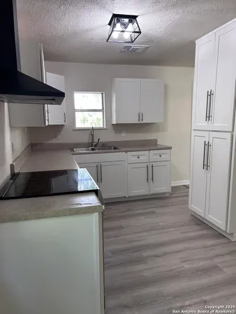 a kitchen with granite countertop a sink stainless steel appliances and cabinets