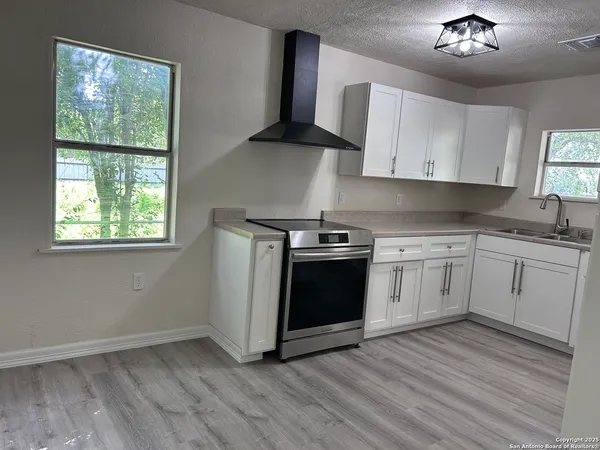 a kitchen with a white stove top oven and sink
