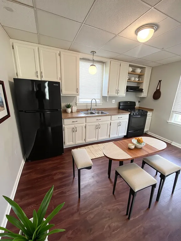 21142 Locust Street Matteson, IL 60443 - Photo 5 of 18 a kitchen with stainless steel appliances wooden floor dining table and chairs