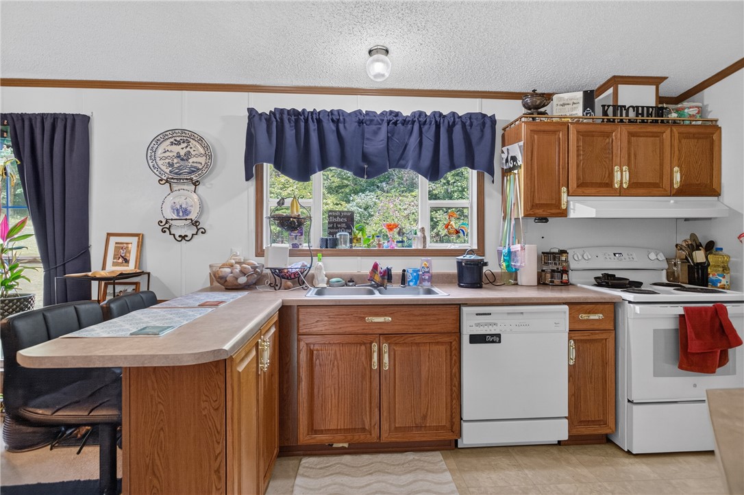 418 Chauga Road Westminster, SC 29693 - Photo 7 of 38 A well-equipped kitchen with warm wood cabinetry and durable countertops, offering a casual breakfast bar for everyday dining.