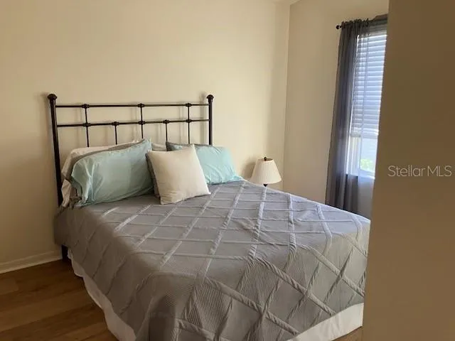a large bed sitting in a bedroom next to a window