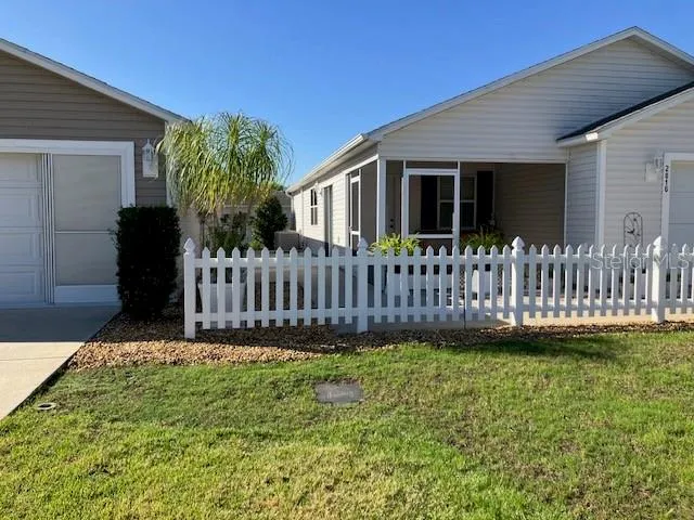 a view of a house with a small yard and wooden fence