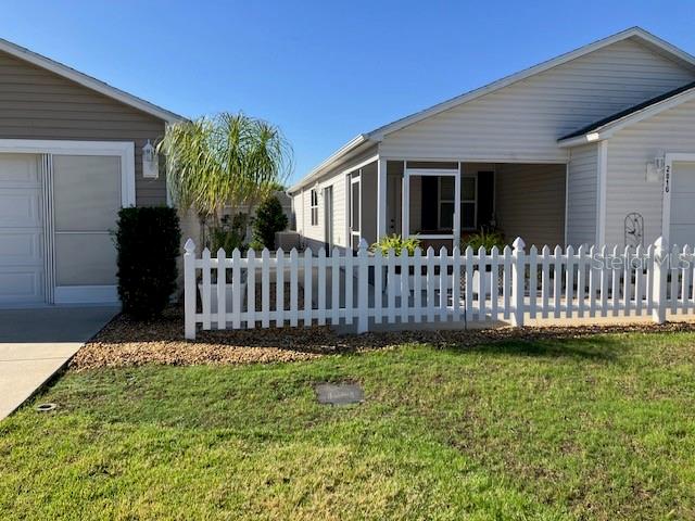 2016 Peaceful Place The Villages, FL 32162 - Photo 2 of 20 a view of a house with a small yard and wooden fence