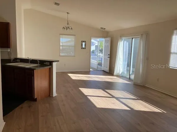 an empty room with kitchen appliances and windows