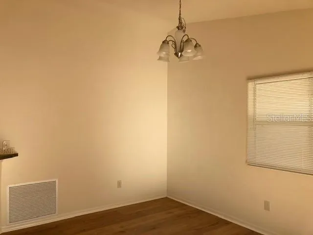 a view of a room with wooden floor and windows